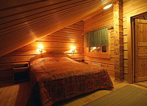 На фото - уютная спальня в мансарде бани.